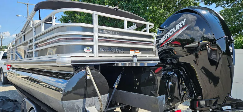 Slide: The Image of 2022 Ranger 223FC pontoon boat with Mercury outboard motor, docked outdoors. - 6