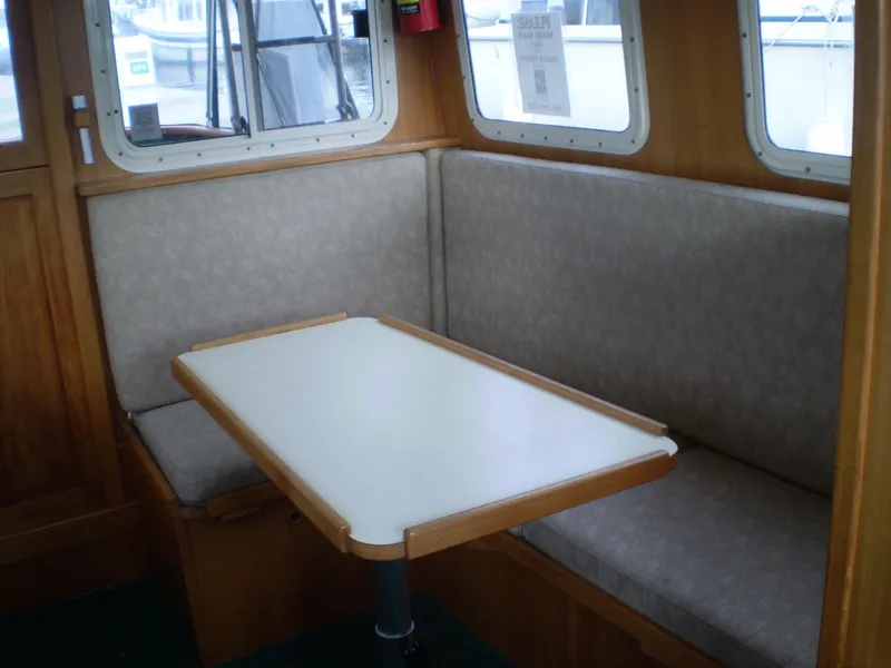 Slide: The Image of Interior of 2001 Maple Bay 32' Trawler with cozy dining area and cushioned seating. - 11