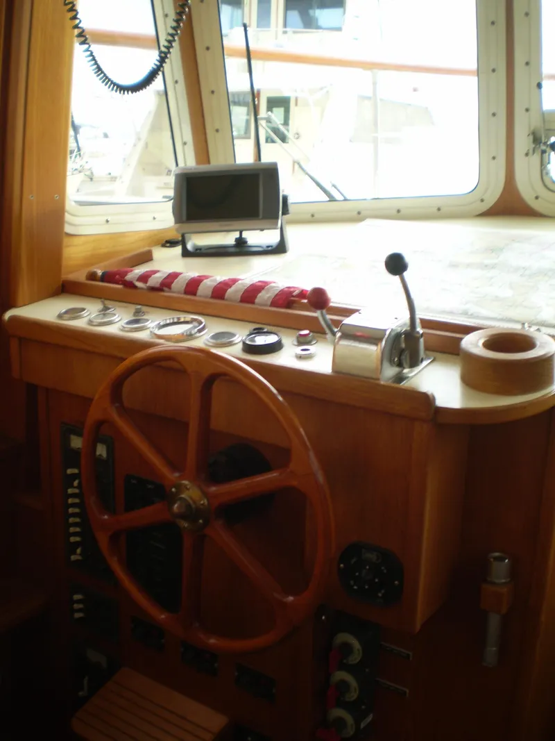 Slide: The Image of Interior helm of 2001 Maple Bay 32' Trawler with wooden steering wheel and navigation equipment. - 12