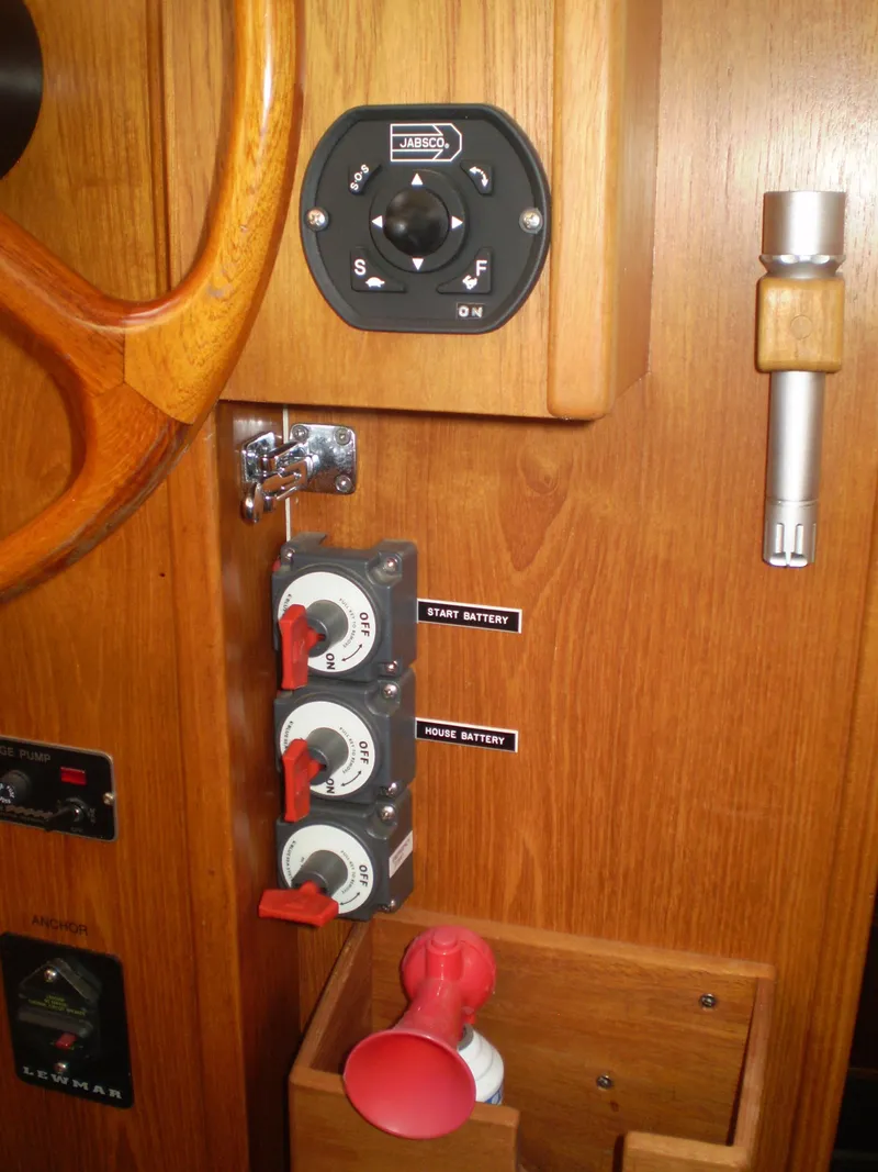 Slide: The Image of Control panel of a 2001 Maple Bay 32' Trawler with labeled switches and wooden finish. - 17