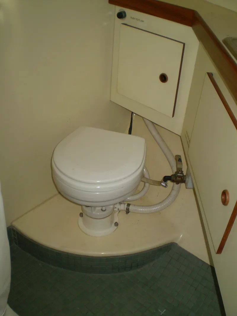 Slide: The Image of 2001 Maple Bay 32' Trawler bathroom with compact marine toilet and storage cabinet. - 22