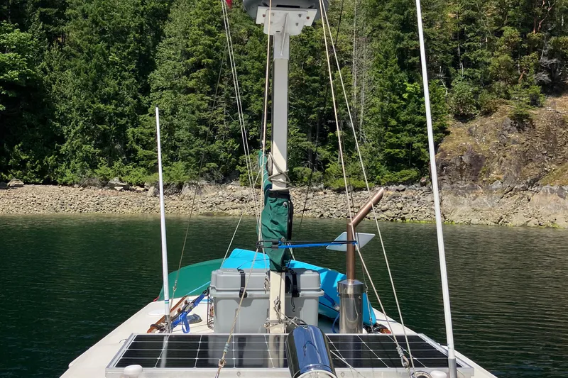 Slide: The Image of 2001 Maple Bay 32' Trawler on calm water, surrounded by lush forest. - 28