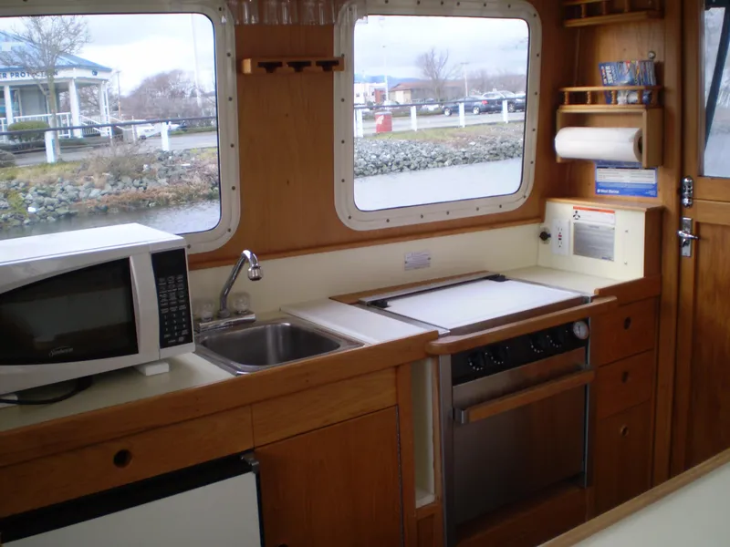 Slide: The Image of Interior of 2001 Maple Bay 32' Trawler with kitchen amenities and scenic window views. - 9