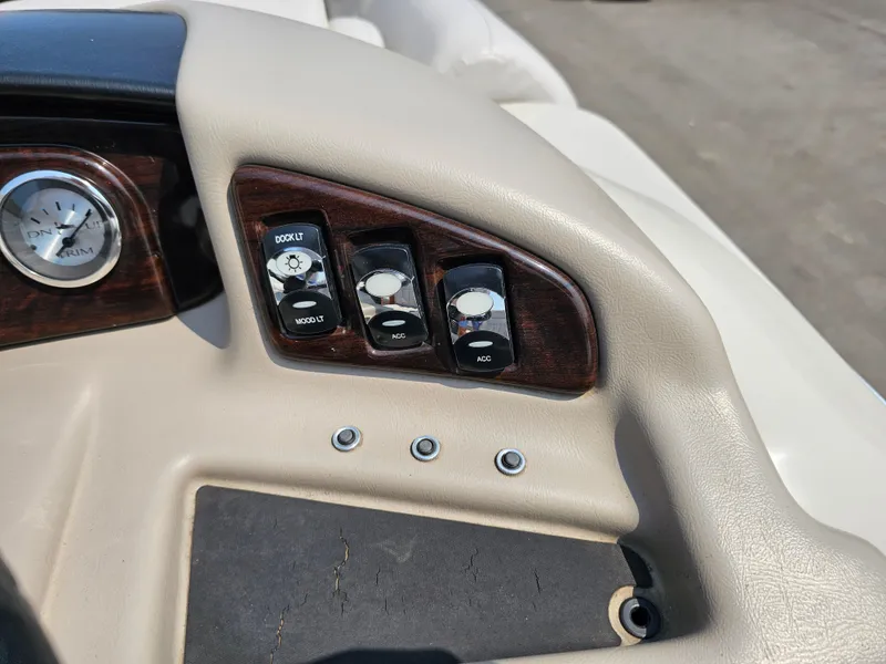 Slide: The Image of Dashboard controls of a 2014 Bennington 2275 GL boat, featuring switches and a gauge. - 12