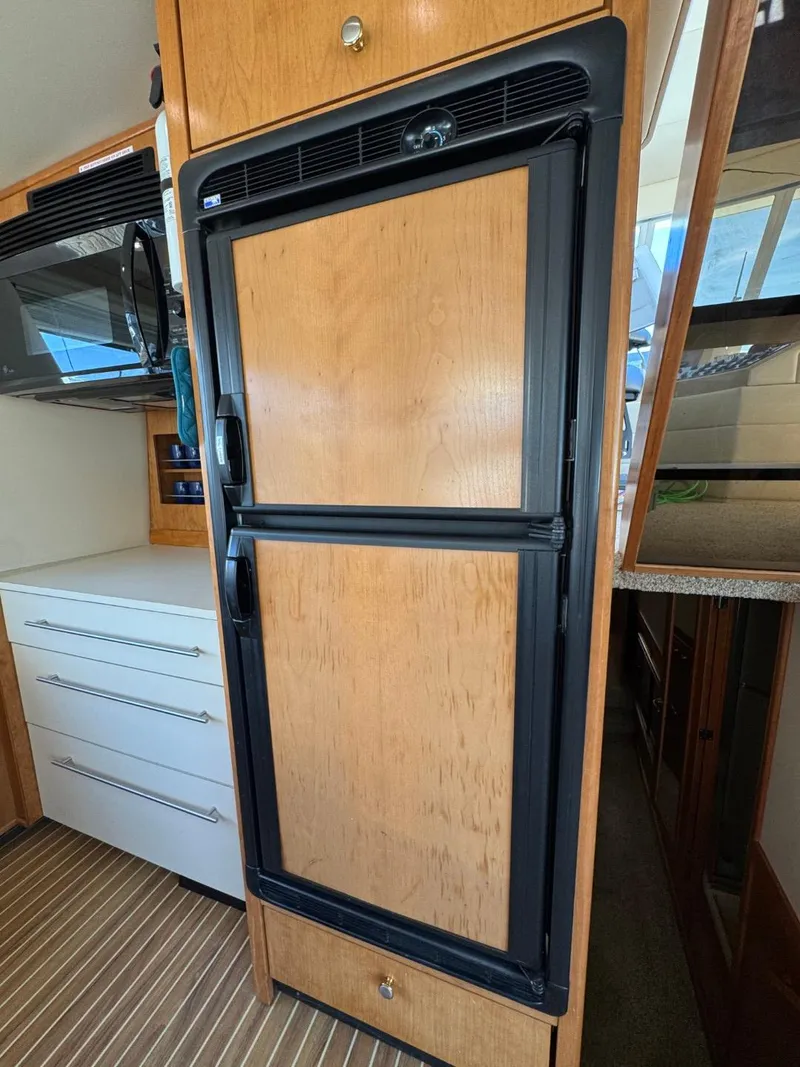 Slide: The Image of Wood-paneled refrigerator in 2003 Meridian 490 Pilothouse Motor Yacht kitchen. - 10