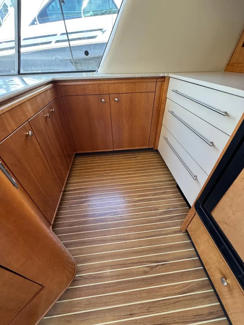 Slide: The Image of Interior of 2003 Meridian 490 Pilothouse Motor Yacht with wood cabinetry and striped flooring. - 11