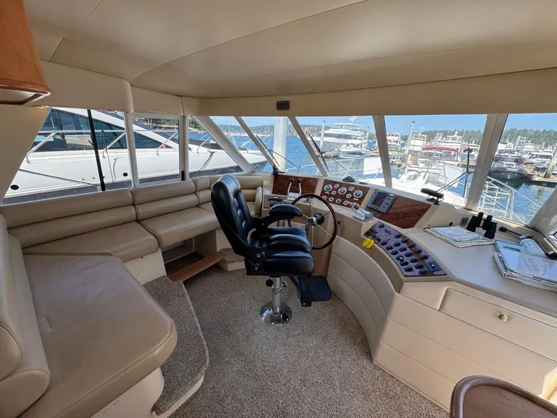 Slide: The Image of 2003 Meridian 490 Pilothouse Motor Yacht interior with helm, seating, and marina view. - 18