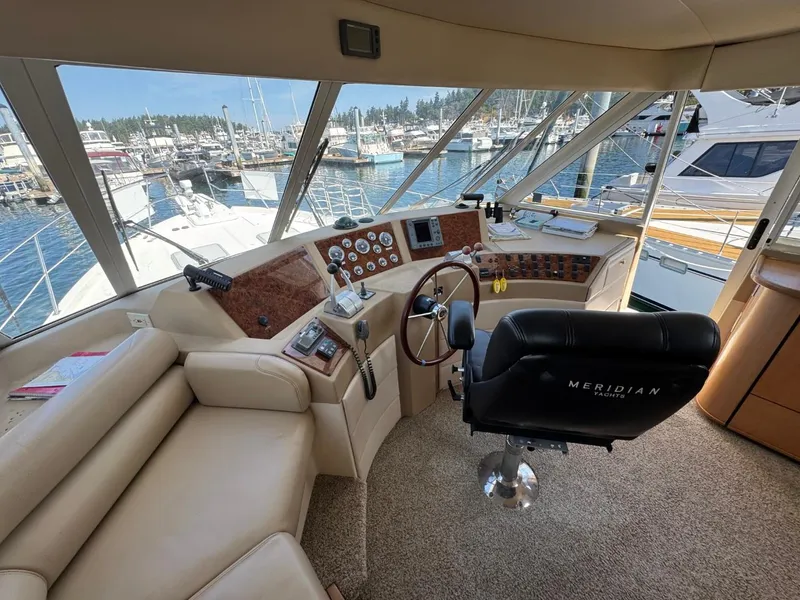 Slide: The Image of Pilothouse interior of 2003 Meridian 490 Motor Yacht, featuring helm and marina view. - 19
