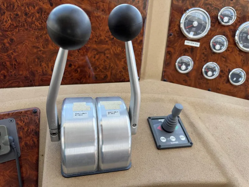 Slide: The Image of 2003 Meridian 490 Pilothouse Motor Yacht controls and gauges on the dashboard. - 22