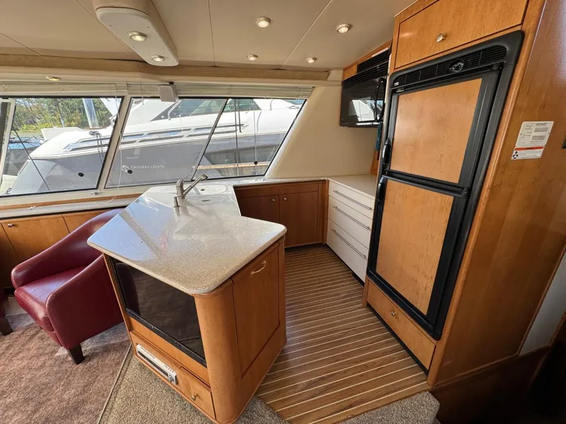 Slide: The Image of Luxurious 2003 Meridian 490 Pilothouse Motor Yacht interior with modern kitchen and seating area. - 9