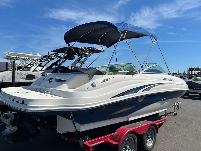 Slide: The Image of 2004 Sea Ray 220 Sundeck boat on trailer under blue sky. - 1