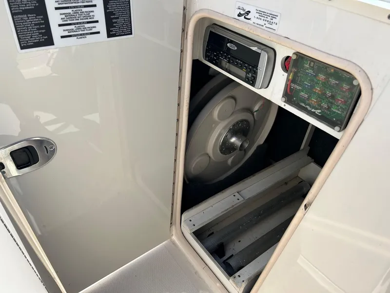 Slide: The Image of 2004 Sea Ray 220 Sundeck storage compartment with stereo system and fuse panel. - 11