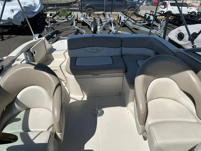Slide: The Image of 2004 Sea Ray 220 Sundeck interior with seating and boat trailers in the background. - 15