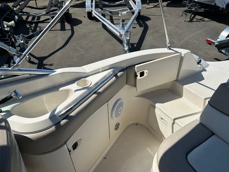 Slide: The Image of 2004 Sea Ray 220 Sundeck interior with seating, cup holder, and storage compartment. - 17