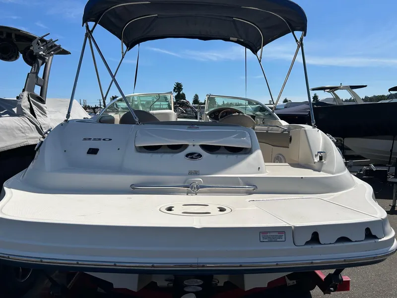 Slide: The Image of 2004 Sea Ray 220 Sundeck boat with canopy, parked outdoors on a sunny day. - 18