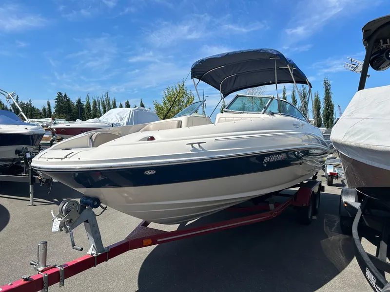 Slide: The Image of 2004 Sea Ray 220 Sundeck boat on trailer under clear blue sky. - 2
