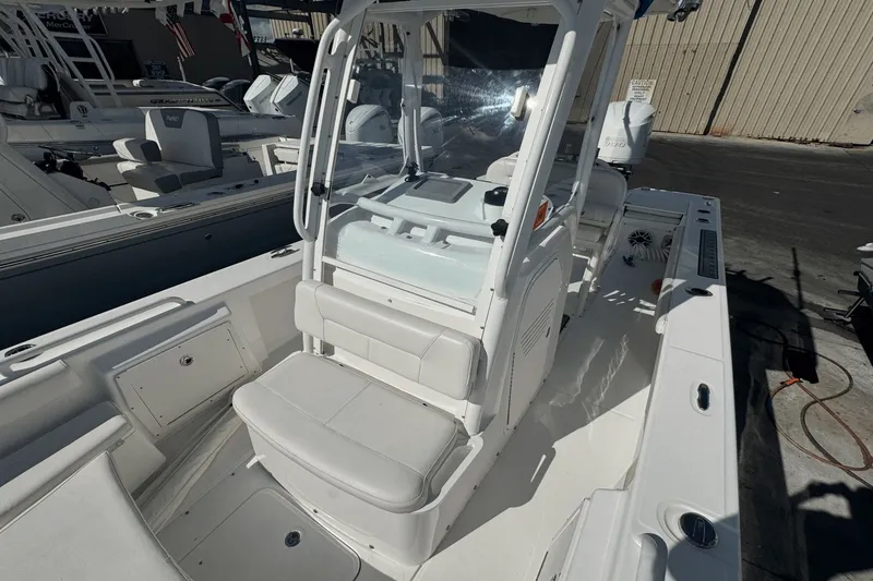 Slide: The Image of 2021 Everglades 243 CC boat interior with seating and console, docked outdoors. - 11