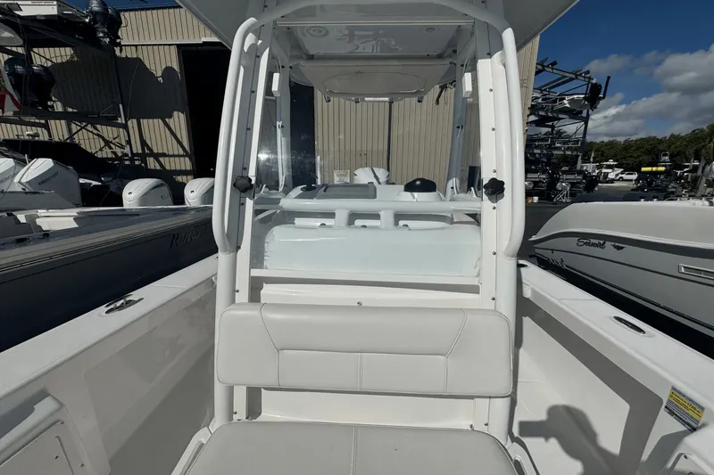 Slide: The Image of 2021 Everglades 243 CC boat interior with seating and console, docked outdoors. - 12