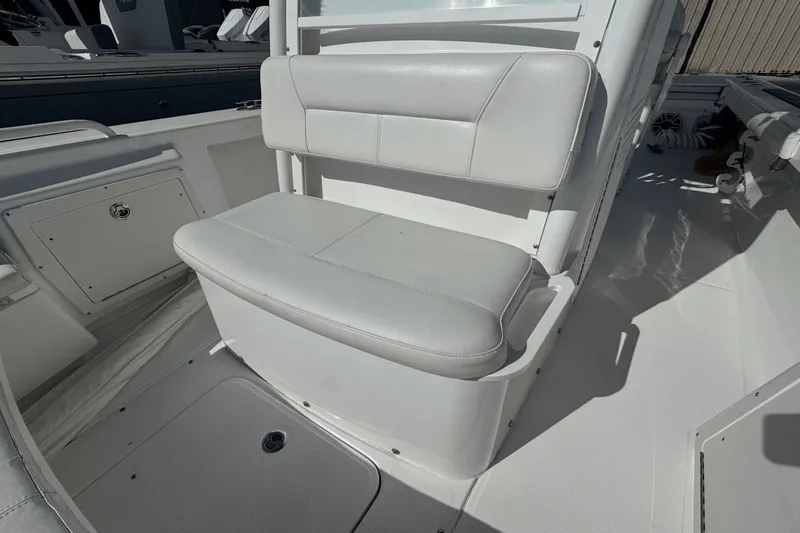 Slide: The Image of 2021 Everglades 243 CC boat interior with white cushioned seating and storage compartments. - 13
