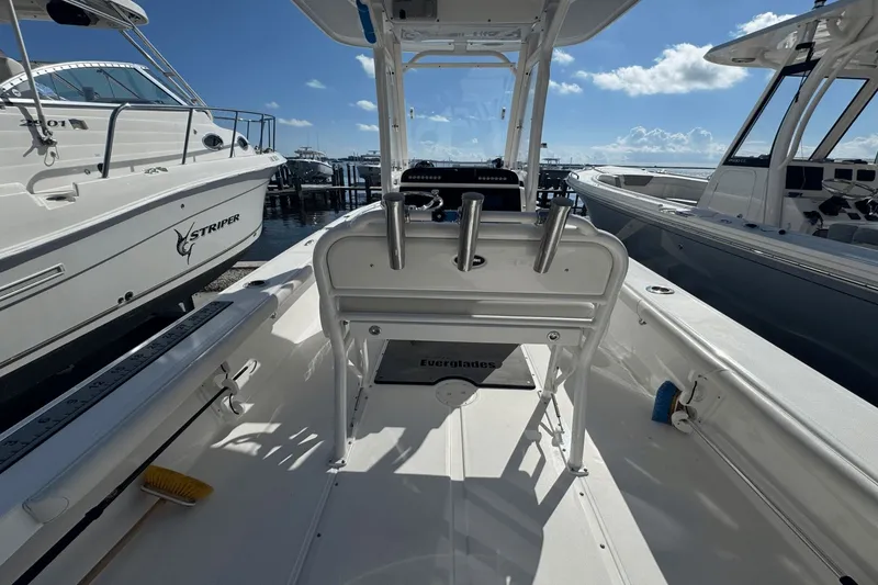 Slide: The Image of 2021 Everglades 243 CC boat interior at marina, sunny day, surrounded by other boats. - 19