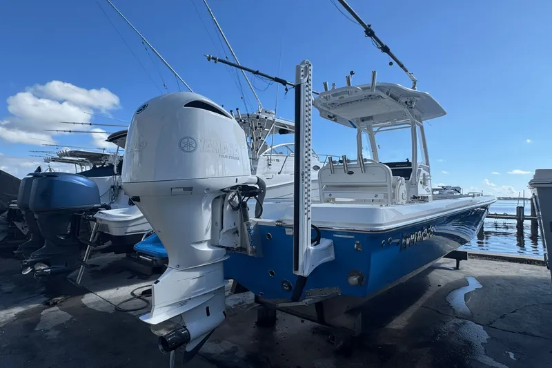 Slide: The Image of 2021 Everglades 243 CC boat with Yamaha outboard motor, docked under a clear blue sky. - 2