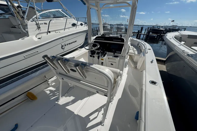 Slide: The Image of 2021 Everglades 243 CC boat docked, featuring a sleek console and rod holders. - 20