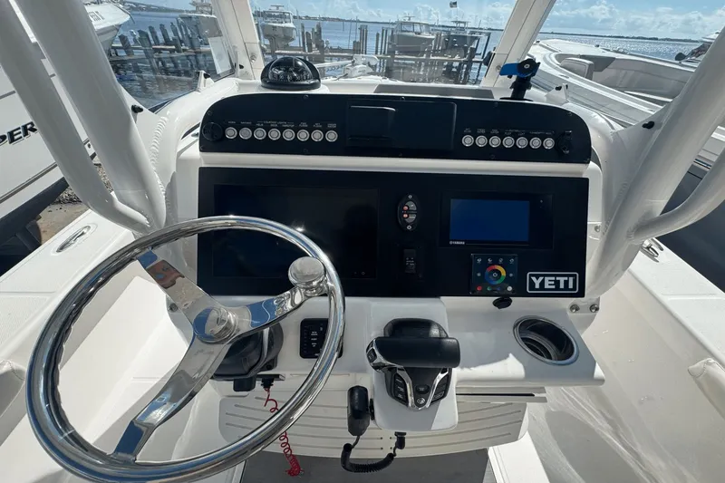Slide: The Image of 2021 Everglades 243 CC boat dashboard with steering wheel and navigation controls. - 28