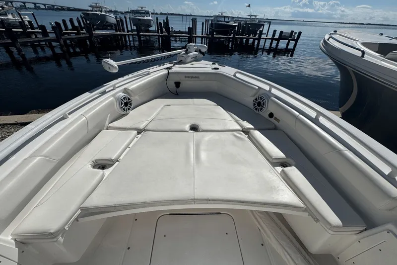 Slide: The Image of 2021 Everglades 243 CC boat interior with white seating, docked by the water. - 7