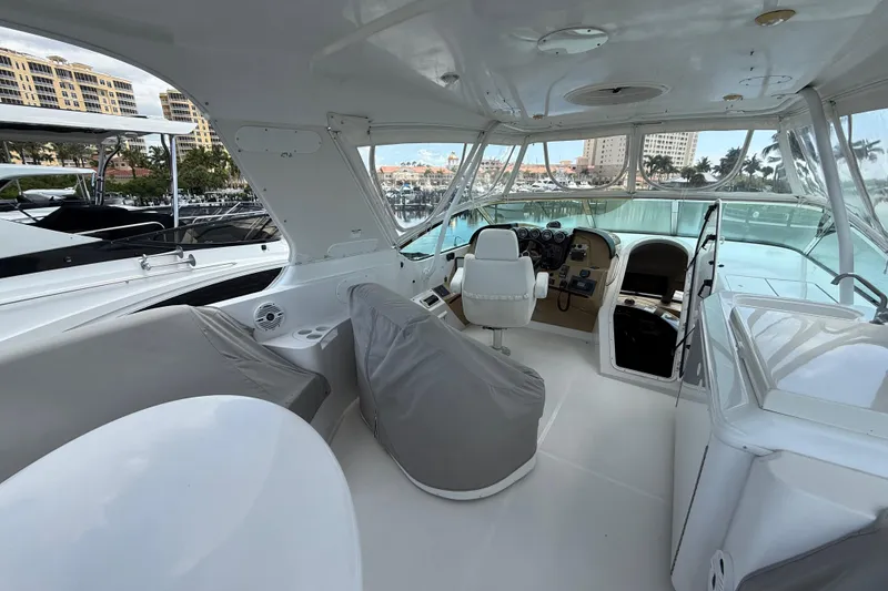 Slide: The Image of 2002 Carver 570 Voyager Pilothouse interior with helm, seating, and marina view. - 8