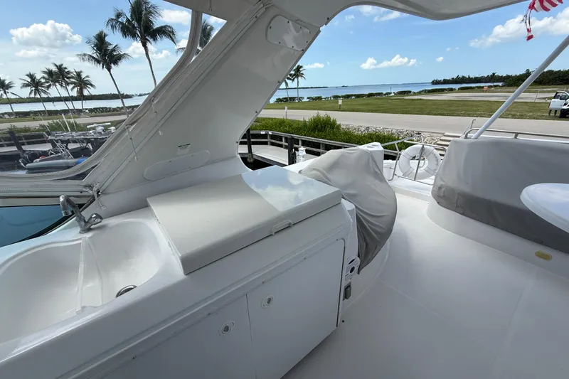 Slide: The Image of 2002 Carver 570 Voyager Pilothouse yacht deck with ocean view and palm trees. - 9