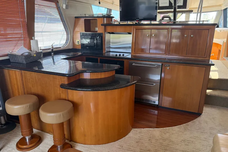 Slide: The Image of Luxurious kitchen interior of 2002 Carver 570 Voyager Pilothouse yacht with wood cabinetry. - 14