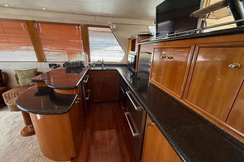 Slide: The Image of Luxurious kitchen interior of 2002 Carver 570 Voyager Pilothouse yacht with wood cabinetry. - 15