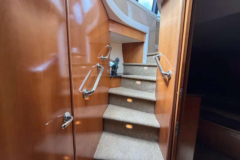 Slide: The Image of Interior staircase of 2002 Carver 570 Voyager Pilothouse with wooden finish and carpeted steps. - 18
