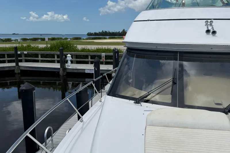 Slide: The Image of 2002 Carver 570 Voyager Pilothouse docked by a serene waterfront. - 5