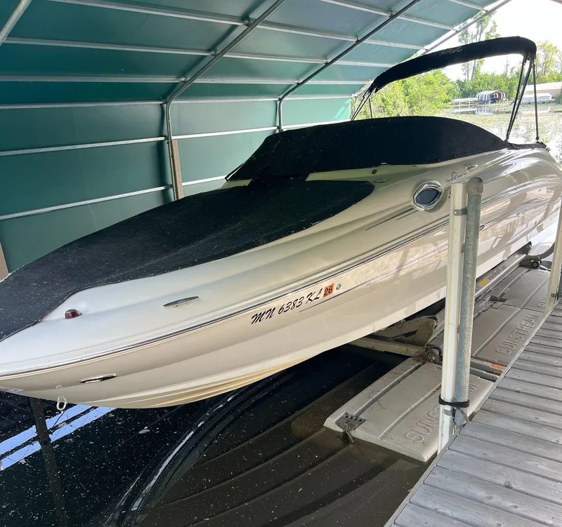 Slide: The Image of 2008 Sea Ray 240 Sundeck boat on lift under a covered dock. - 0