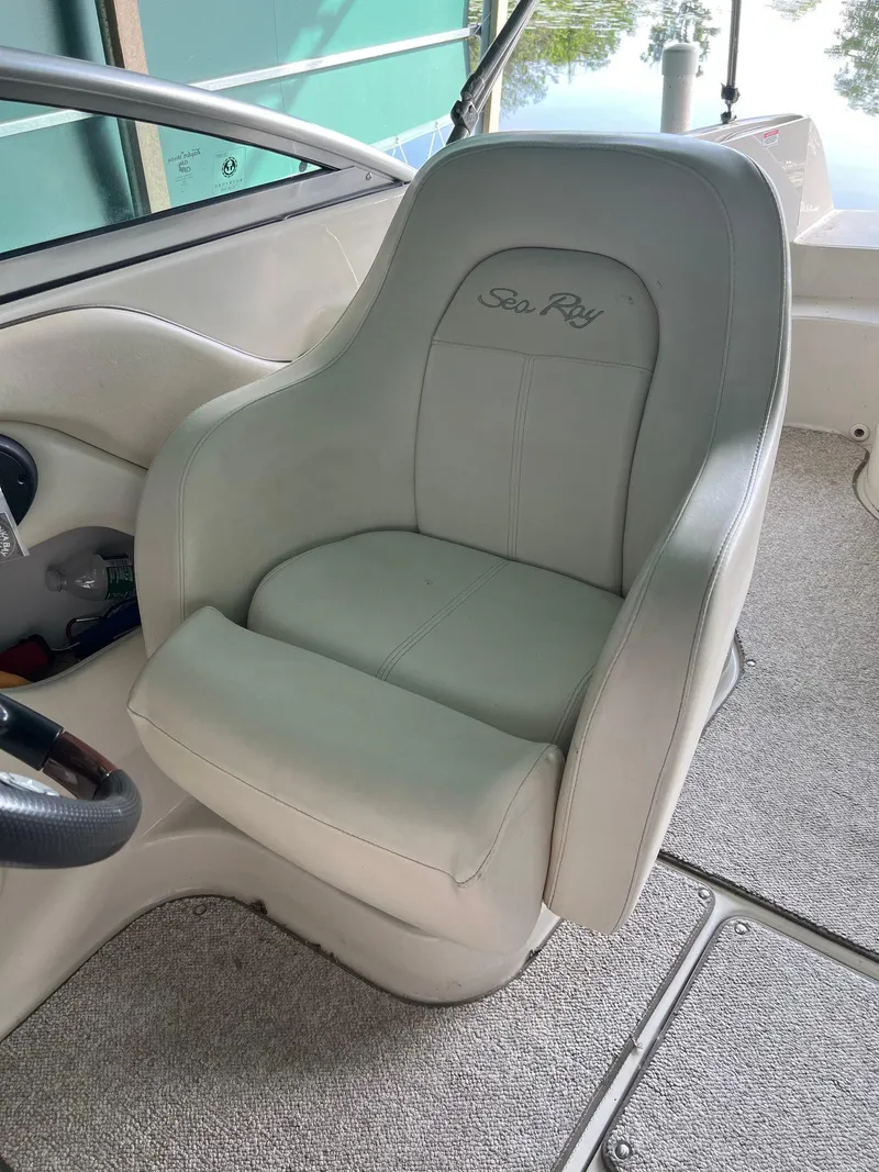 Slide: The Image of Captain's seat on 2008 Sea Ray 240 Sundeck boat, featuring plush white upholstery. - 16