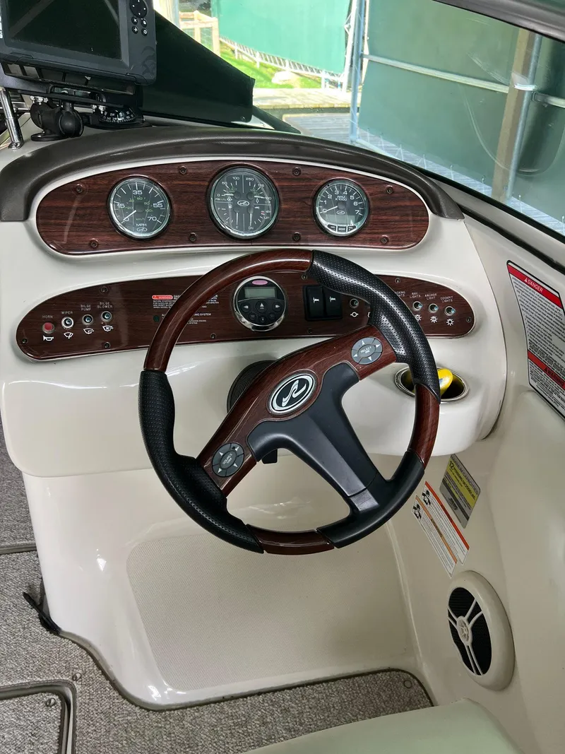 Slide: The Image of 2008 Sea Ray 240 Sundeck dashboard with steering wheel and instrument panel. - 19