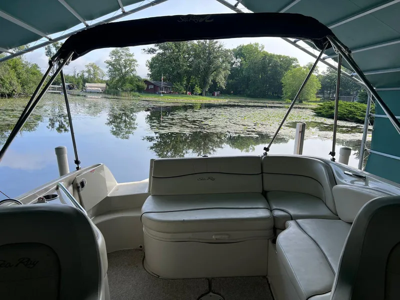 Slide: The Image of 2008 Sea Ray 240 Sundeck interior with lake view and lush greenery. - 22