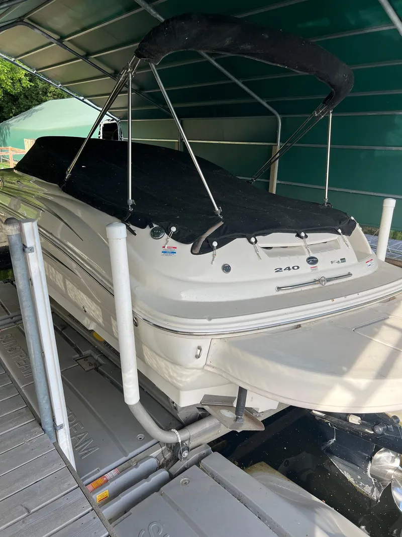 Slide: The Image of 2008 Sea Ray 240 Sundeck boat under a canopy on a lift. - 23