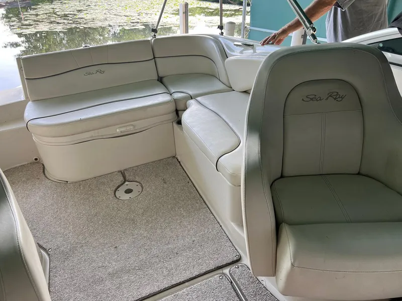 Slide: The Image of 2008 Sea Ray 240 Sundeck interior with beige seating and carpeted floor. - 26