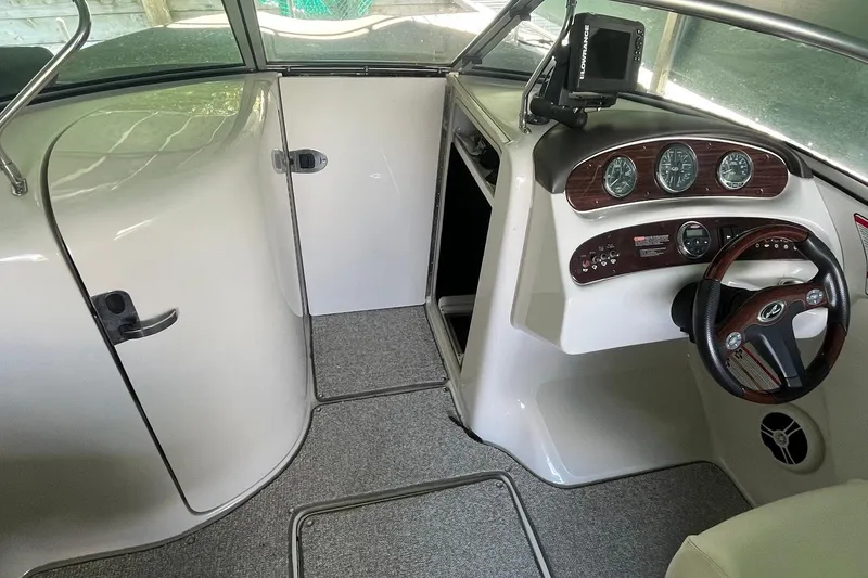 Slide: The Image of 2008 Sea Ray 240 Sundeck interior with steering wheel, gauges, and navigation system. - 36
