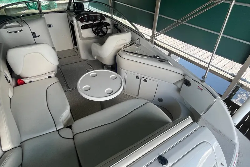 Slide: The Image of 2008 Sea Ray 240 Sundeck interior with seating and steering wheel under canopy. - 4