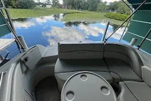 Slide: The Image of 2008 Sea Ray 240 Sundeck interior with lake view, featuring seating and table. - 6