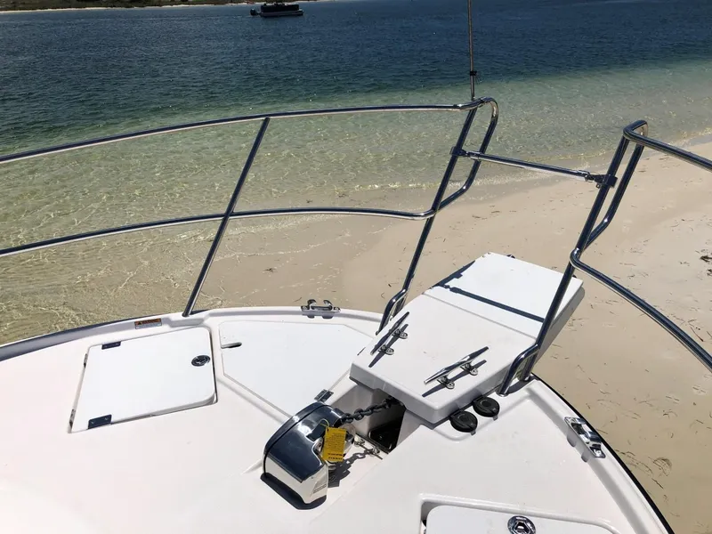 Slide: The Image of 2025 Cutwater C-32 Sedan boat anchored on sandy beach with clear water. - 15