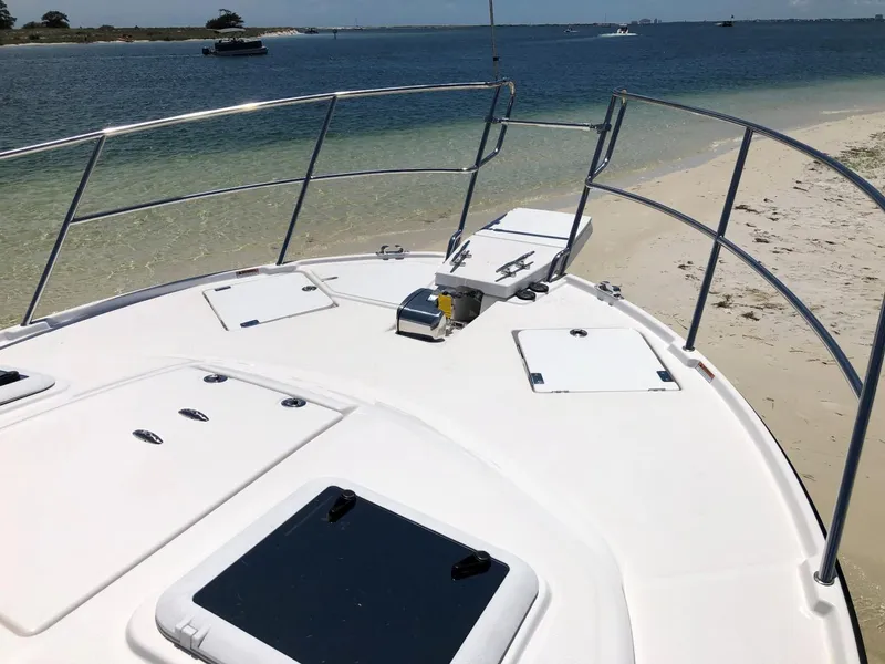 Slide: The Image of 2025 Cutwater C-32 Sedan boat deck near sandy beach and calm waters. - 16