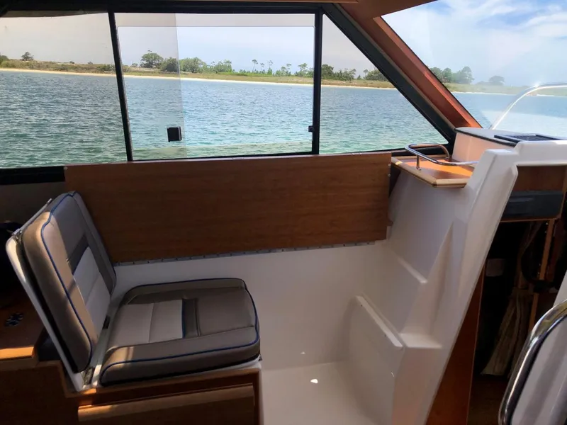 Slide: The Image of Interior of 2025 Cutwater C-32 Sedan boat with seating and water view. - 24