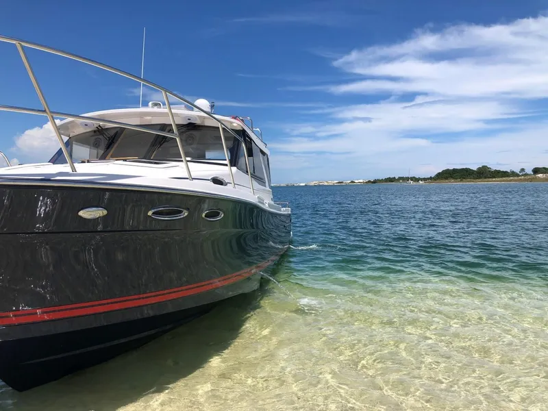 Slide: The Image of 2025 Cutwater C-32 Sedan boat on clear water near sandy shore. - 4