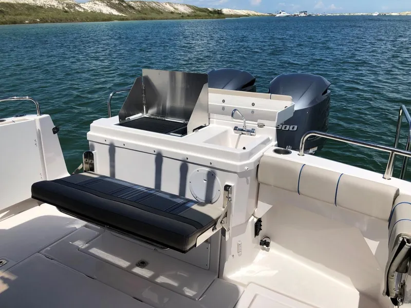 Slide: The Image of 2025 Cutwater C-32 Sedan boat with outdoor seating and dual engines on a serene lake. - 8
