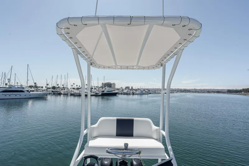 Slide: The Image of 2019 Fountain 38 CC boat helm with canopy, overlooking marina with yachts. - 12