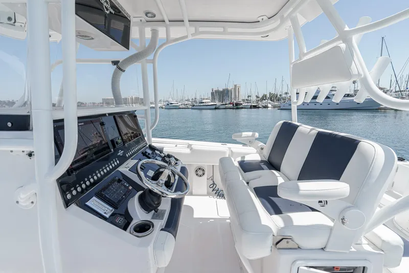 Slide: The Image of 2019 Fountain 38 CC boat interior with modern controls and seating, docked at a marina. - 20